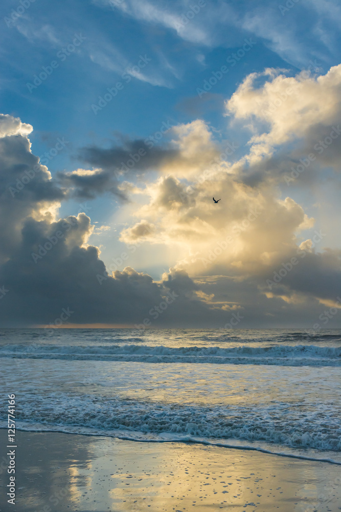 Beautiful morning sunrise over the ocean. Soft waves break on the beach. North Carolina.