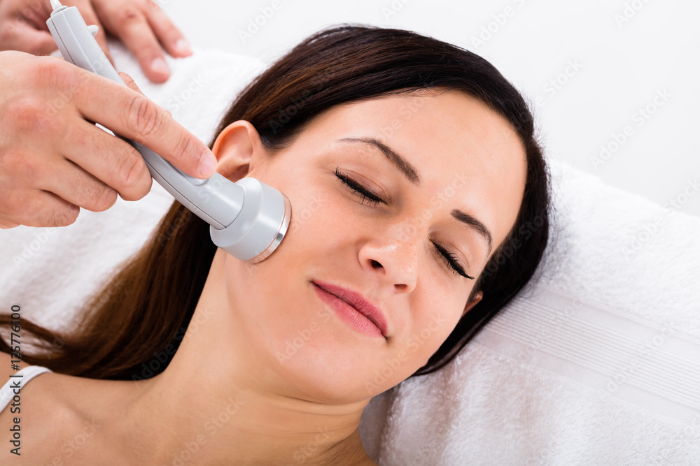 Woman Receiving Microdermabrasion Therapy On Forehead Woman Receiving Microdermabrasion Therapy On Forehead