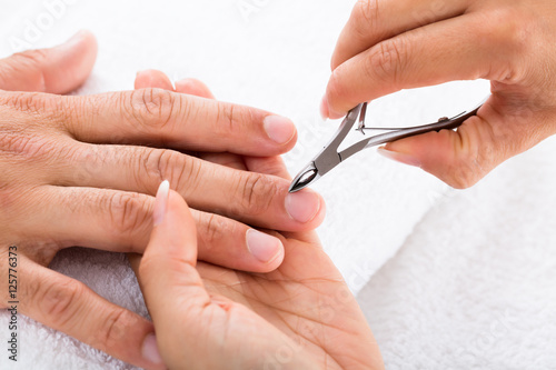 Manicurist Cutting Off The Cuticle From The Person s Fingers