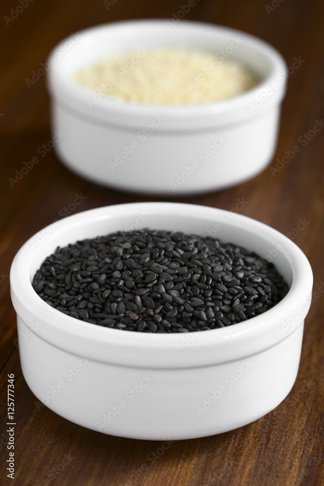 Black and white sesame seeds in small bowls, photographed with natural light (Selective Focus, Focus in the middle of the black seeds) Black and white sesame seeds in small bowls, photographed with natural light (Selective Focus, Focus in the middle of the black seeds)