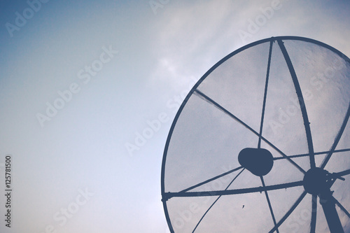 Old satellite dish in morning sky.(Vintage fitered)