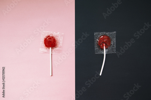 lollipops on pink and black background. the contrast between the whole and broken candy lollipop. the concept of contrast. before and after. top view