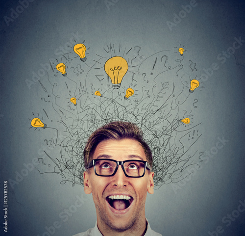Happy man in glasses looking up with light idea bulb above head