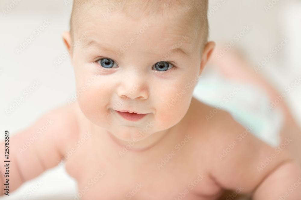 Portrait of an adorable smiling baby holds head up. Family concept photo, lifestyle, closeup Portrait of an adorable smiling baby holds head up. Family concept photo, lifestyle, closeup