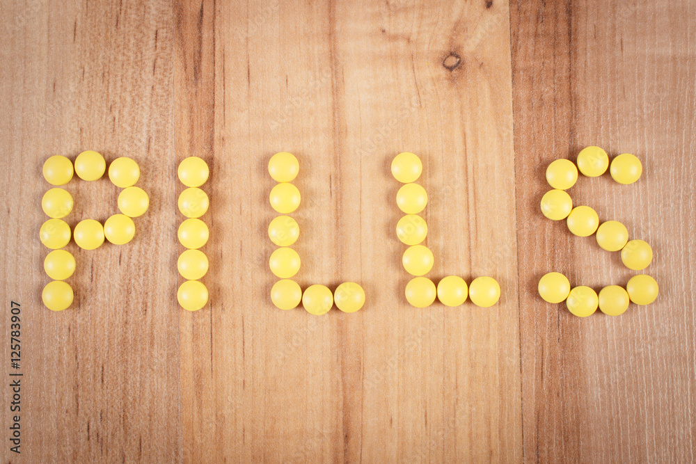 Inscription pills made of yellow medical tablets, health care concept
