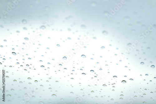 Rain drop on car glass in background.