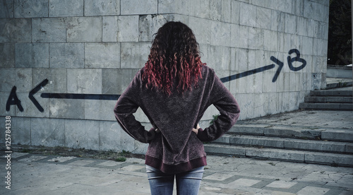 Quadro su tela Young girl in front of a wall painted
