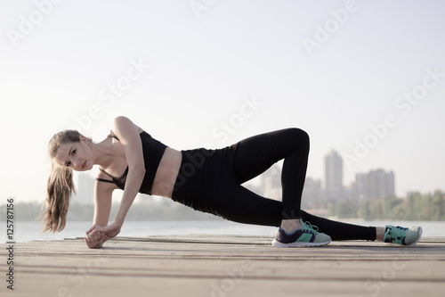 Fitness sporty girl doing plank exercises during training workou photo
