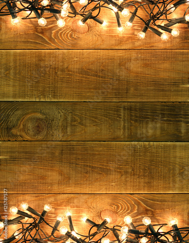 Christmas and New Year background with decorations glowing garland lights lamp on rustic wooden table board. Copyspace wit place for text or logo. Concept backdrop for announcements shop hallyday sale