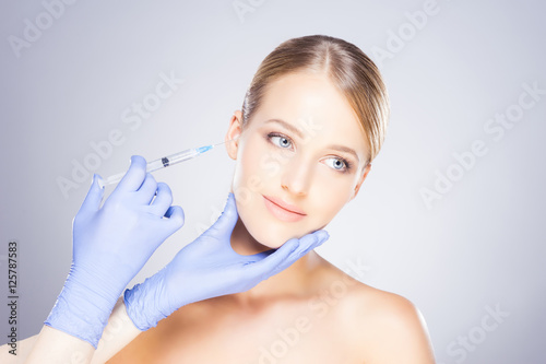 Young blond woman on a face injection procedure