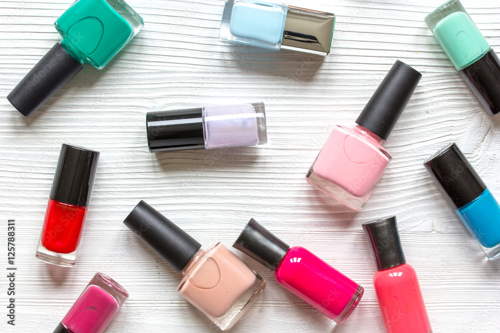 Obraz premium lot of bottles nail polish on wooden background top view