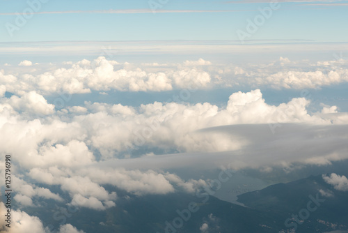 Fototapeta Naklejka Na Ścianę i Meble -  Cloudscape view with mountain  above white clouds  and blue sky from airplane