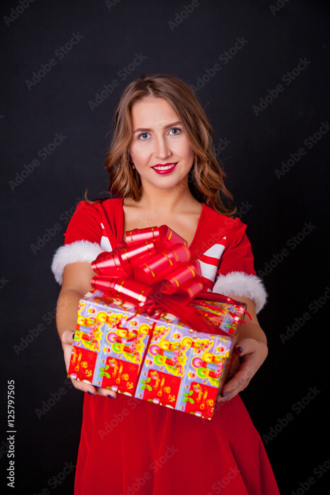 Beautiful girl wearing santa claus clothes with christmas gift Beautiful girl wearing santa claus clothes with christmas gift