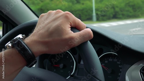 Wallpaper Mural man drives a car in the town - detail of steering wheel with hand Torontodigital.ca