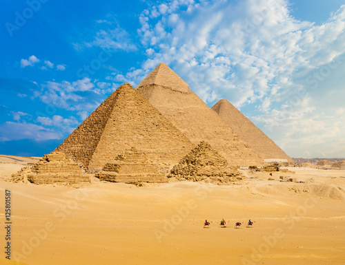 Obraz na plátně All Egypt Pyramids Camels Line Walking Wide Angle