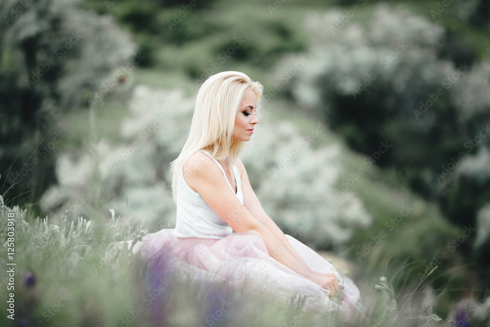 beautiful, gentle and young woman sits on green grass beautiful, gentle and young woman sits on green grass