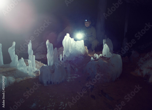  young female caver writing down cave. Grot of Golubinskaya Cave.Arhangelsk region photo