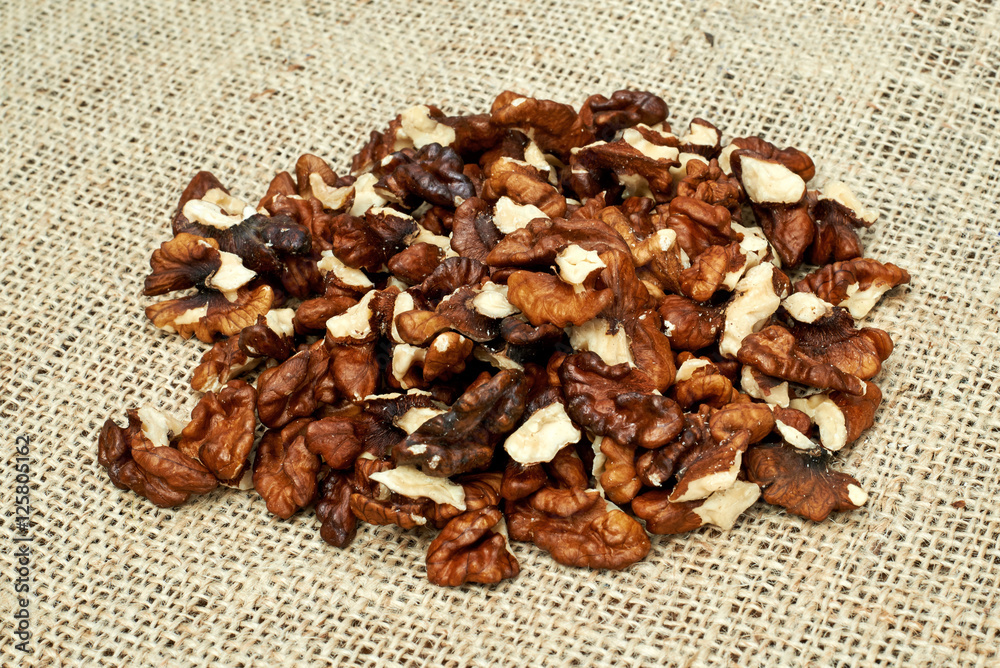 Obraz premium Walnuts on a burlap background.