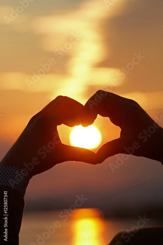 Heart shape silhouette on sunset.
