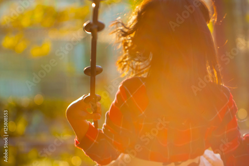 Among the sunset, children playing in the swing