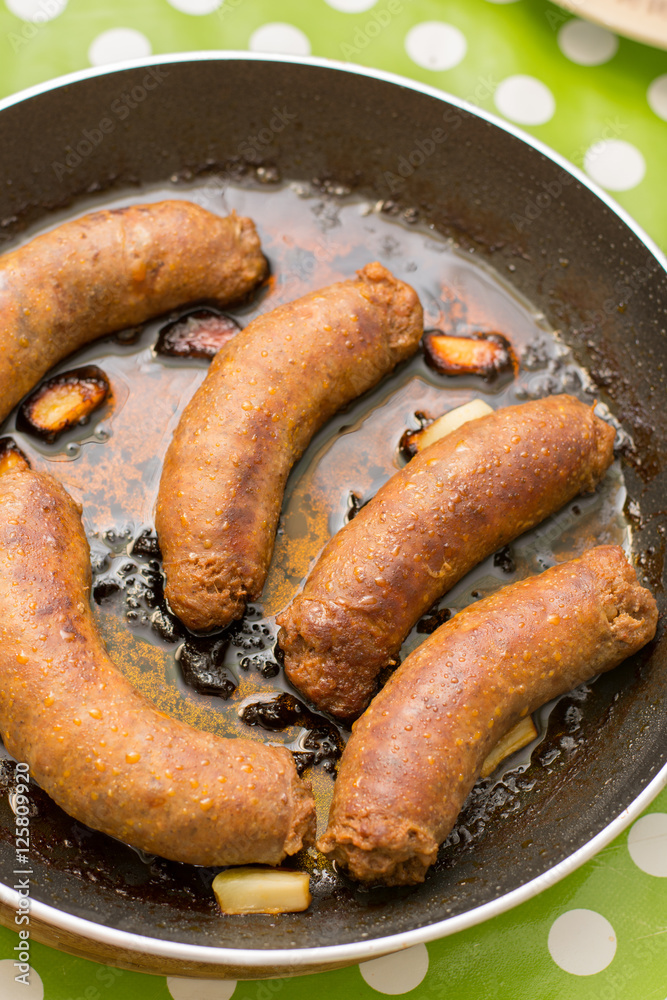 Fried homemade sausages in the frying pan