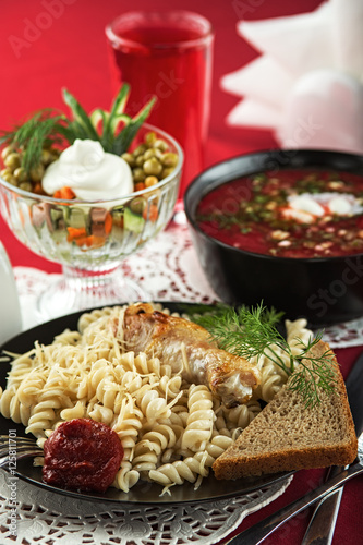 Business lunch in the Russian style: borscht, pasta with grilled chicken, Olivier salad and berry juice
