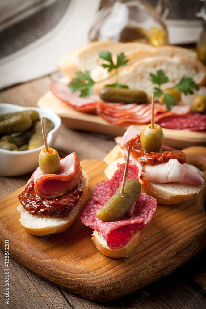 Tapas with sliced sausage, salami, olives and parsley. Tapas with sliced sausage, salami, olives and parsley.