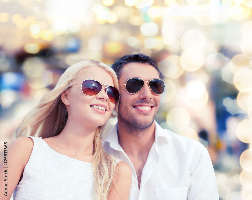 happy couple in shades over lights background