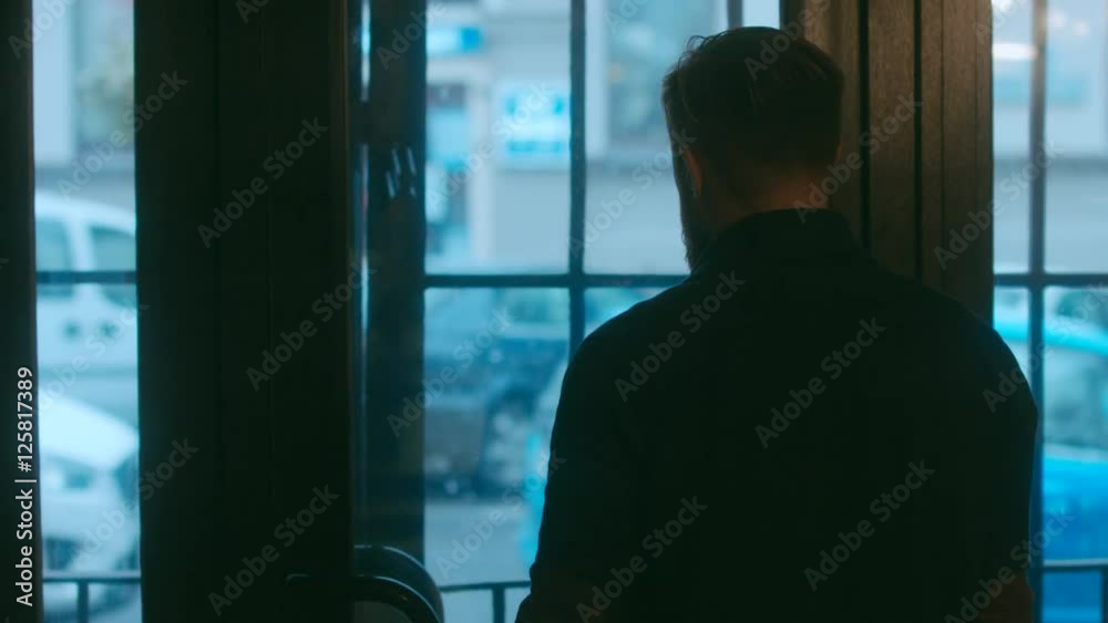 MED Thoughtful bearded man looking out of the window on winter day, urban background. 4K UHD MED Thoughtful bearded man looking out of the window on winter day, urban background. 4K UHD