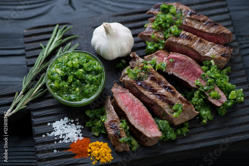 Cuadro en lienzo Sliced barbecued rump steak with chimichurri sauce, close-up