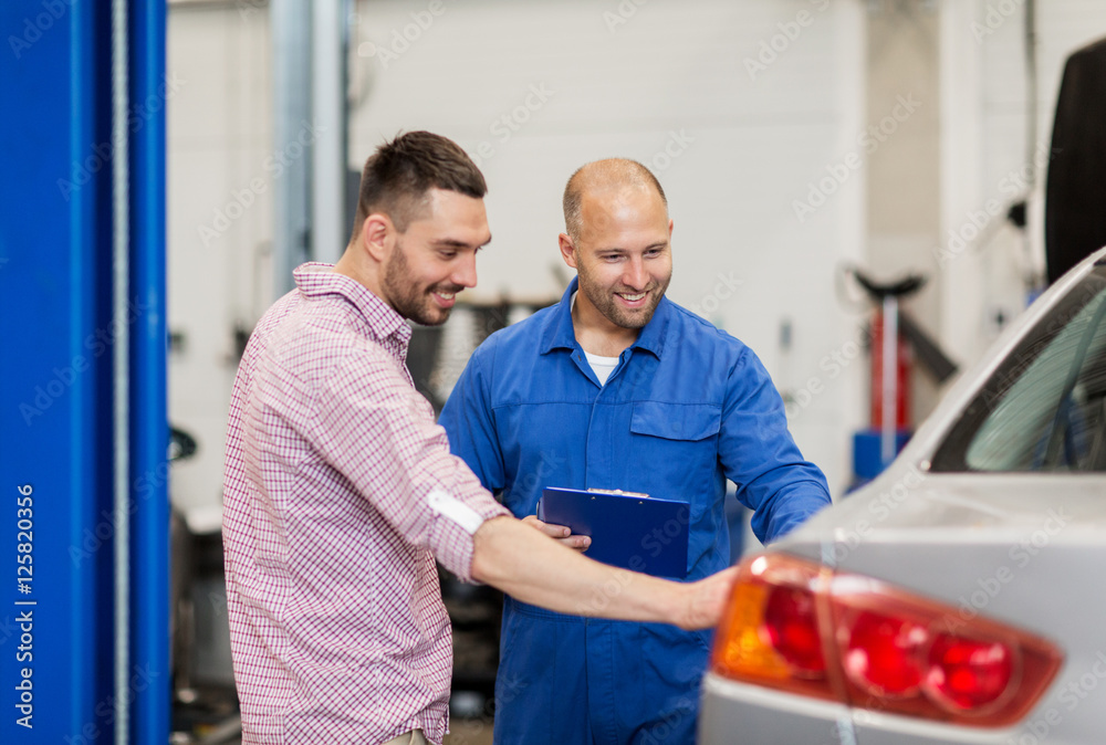 Obraz premium auto mechanic with clipboard and man at car shop