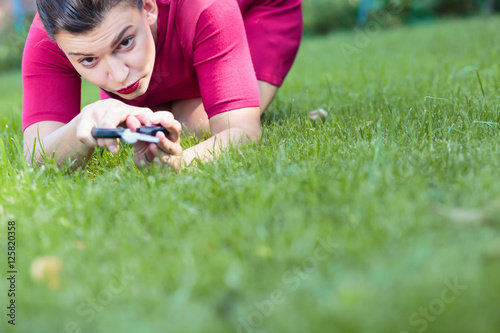 Woman cutting a grass using a scissors photo