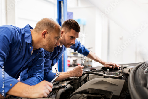 mechanic men with wrench repairing car at workshop