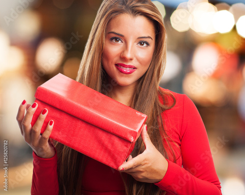 portrait of a beautiful young woman holding a gift box at Christmas