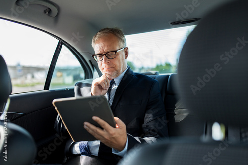senior businessman with tablet pc driving in car © Syda Productions