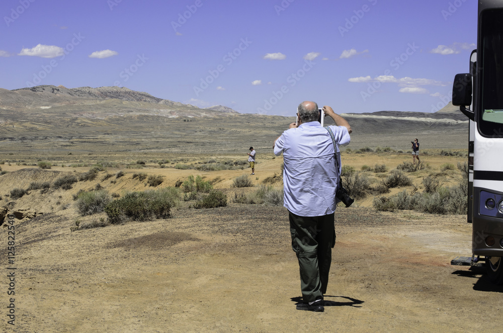 Senior Citizen Videoing Family In Desert with RV Senior Citizen Videoing Family In Desert with RV