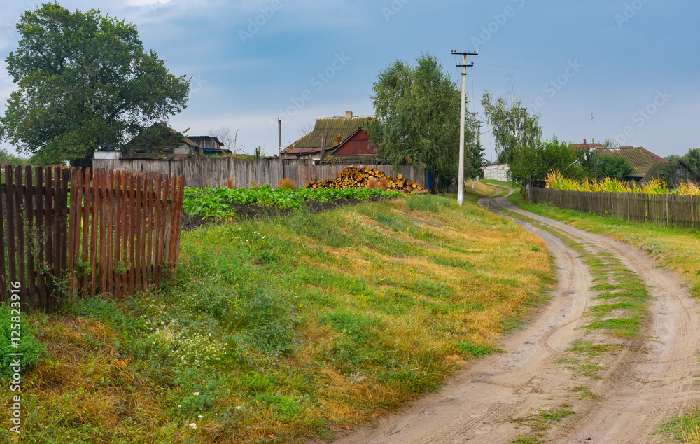 Autumnal scenery with earth road between streets in Boromlya village, Sumskaya oblast, Ukraine
