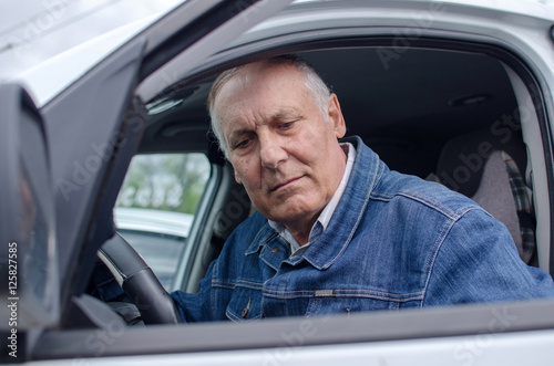Aged man sitting in the car