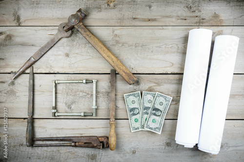 The concept of a house under construction. Old wooden desktop. Old rusty carpentry tools. Horizontal mockup