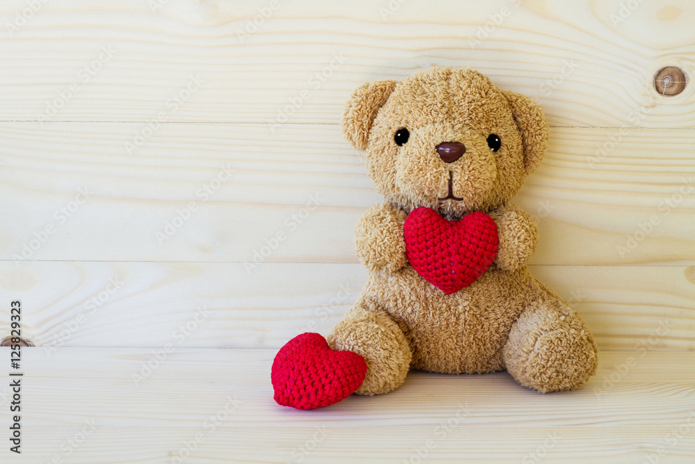 Fototapeta premium Teddy bear holding a heart-shaped pillow