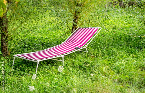 Relaxing place under willow with pink lounge chair . Suitable for use in projects on imagination, creativity and design.