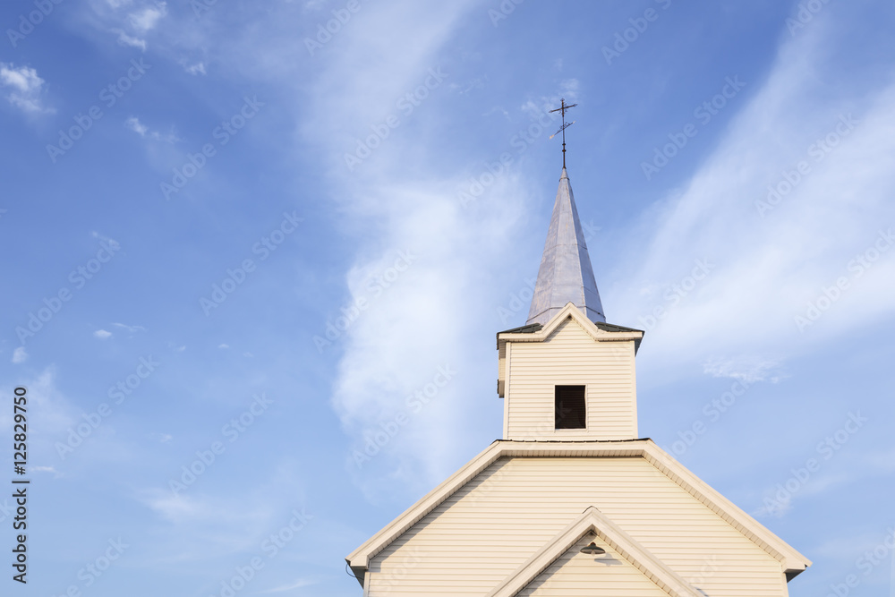 Country church steeple against blue sky and white clouds Country church steeple against blue sky and white clouds