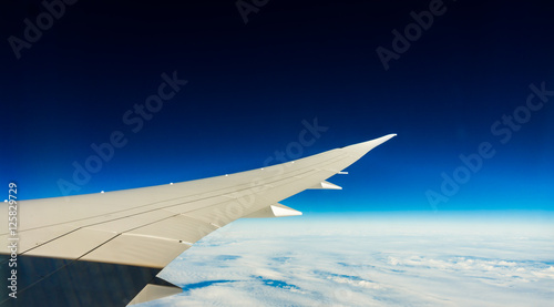 Aircraft wing in flight with wingflex and dark blue sky (Boeing 787)