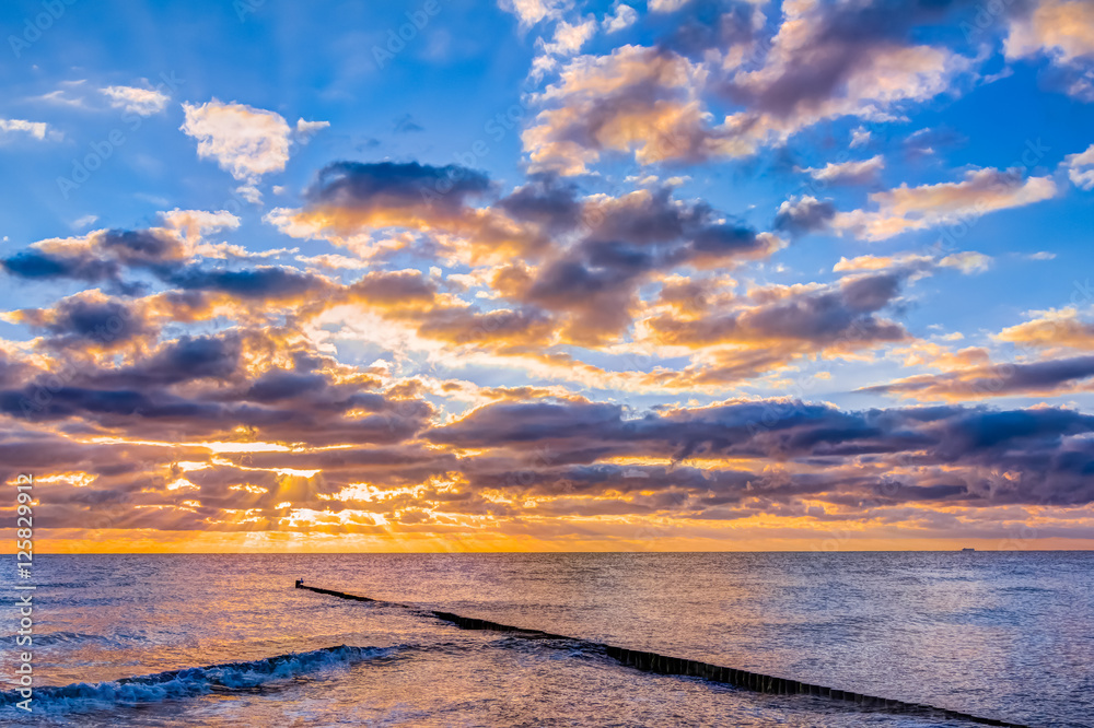 Obraz premium Wonderful sunrise with big clouds at the beach in summer
