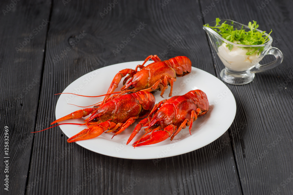 Three red crayfishes on white plate with sauce Three red crayfishes on white plate with sauce