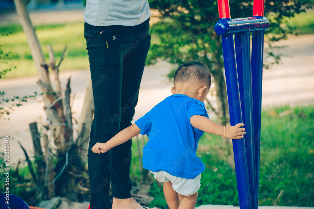 Obraz premium Children playing park and Mom. Little baby playing in the park on the on a sunny day.