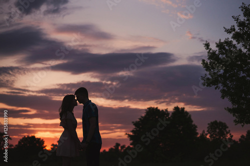 couple's silhouette at sunset in the forest