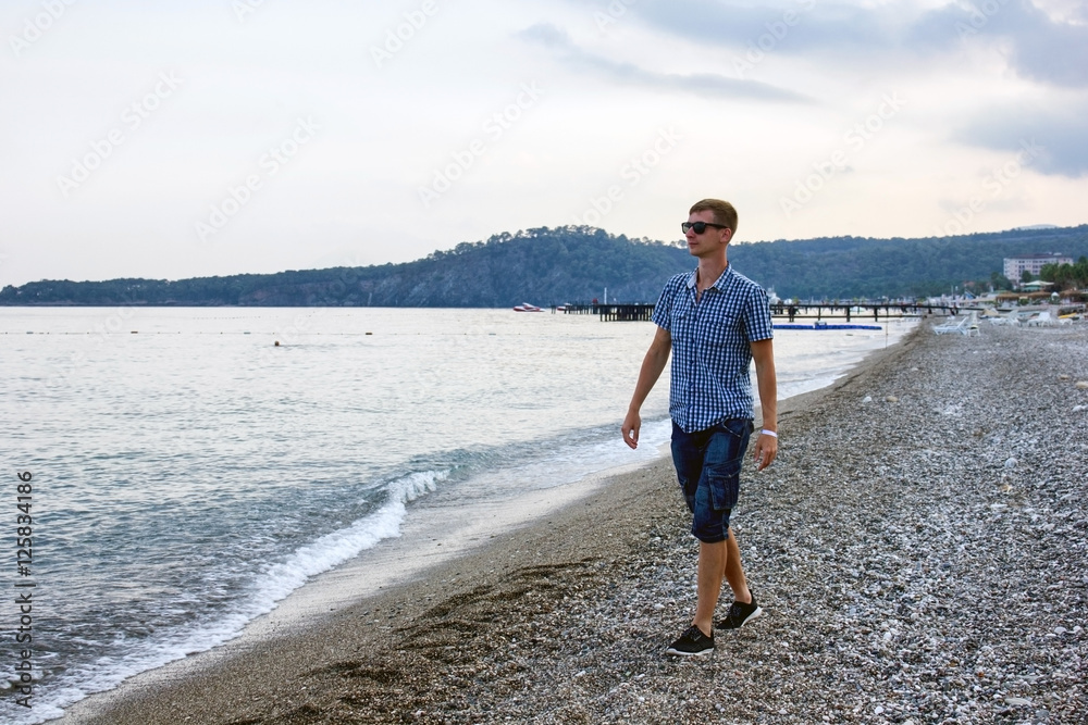  man is walking on the sea shore