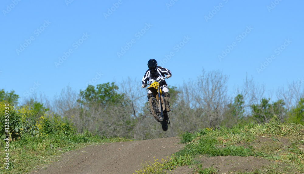 Jump/Motocross rider jumping a small hill.