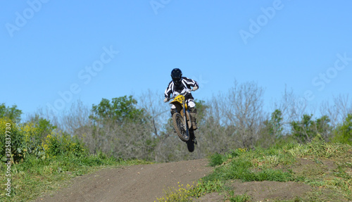 Jump/Motocross rider jumping a small hill.